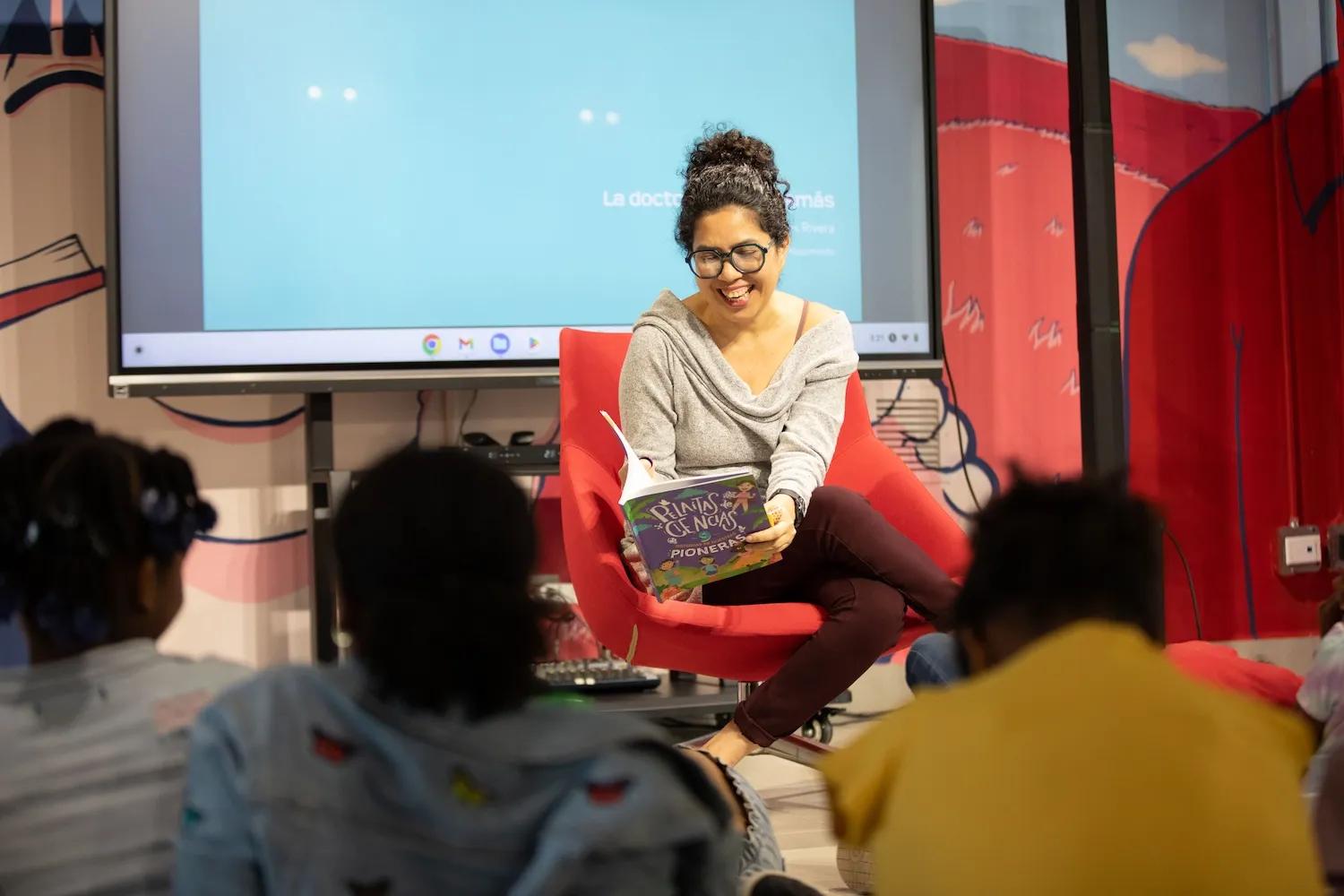 Mujer lee un libro infantil ante la mirada varios niños