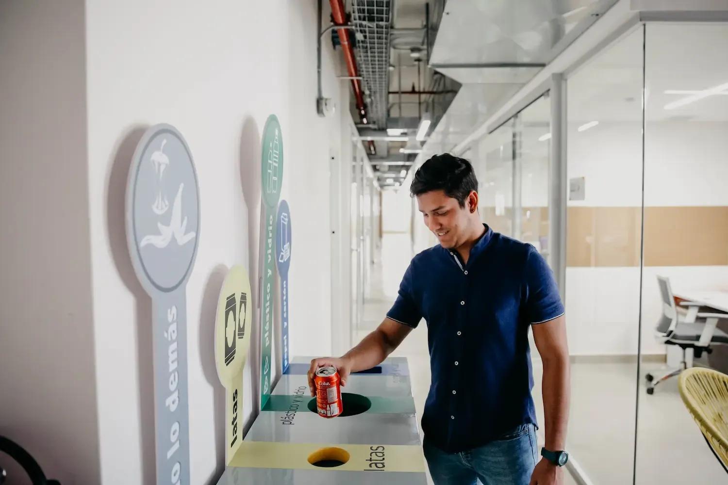 Hombre con lata de una gaseosa, se dispone a ingresarla a una caneca de basura