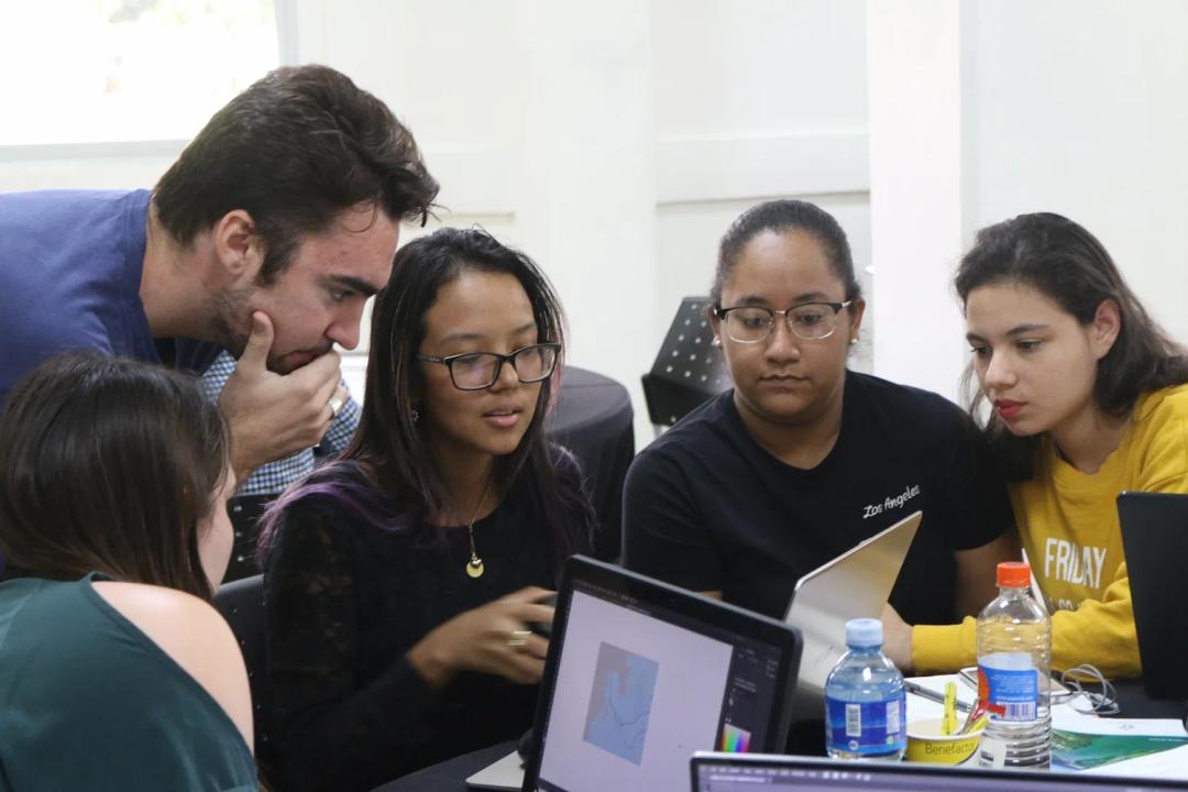 Grupo de personas observan y opinan algo que ven en un computador