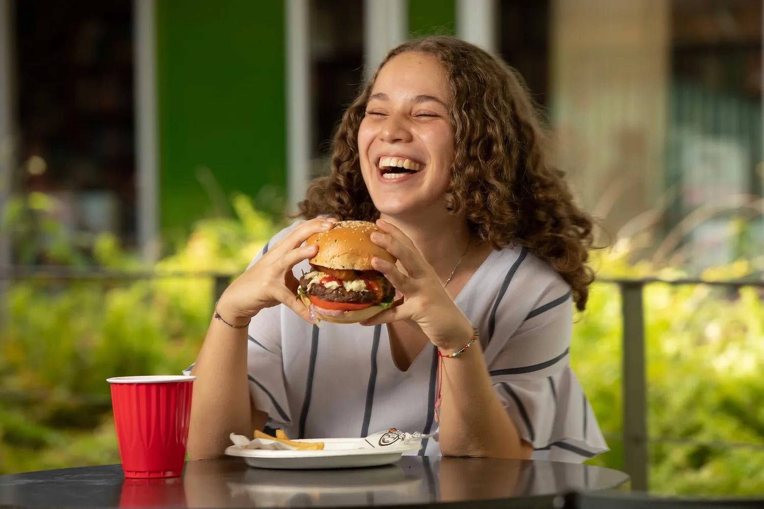 Joven disfruta de una rica hamburguesa en La Plaza de Ciudad del Saber