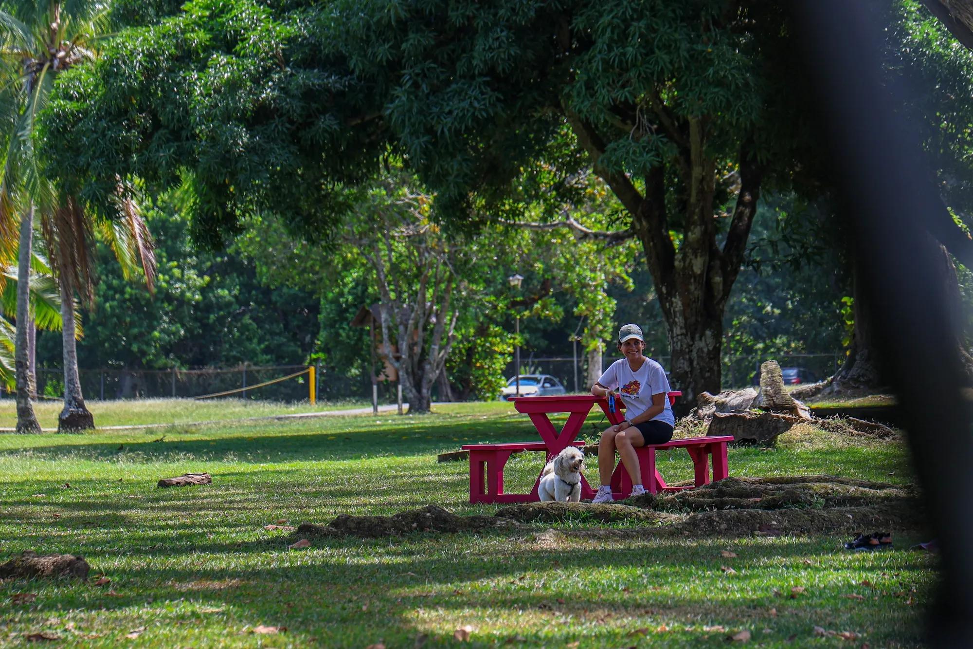Mujer sentada en unas bancas del parque Ciudad del Saber con us mascota