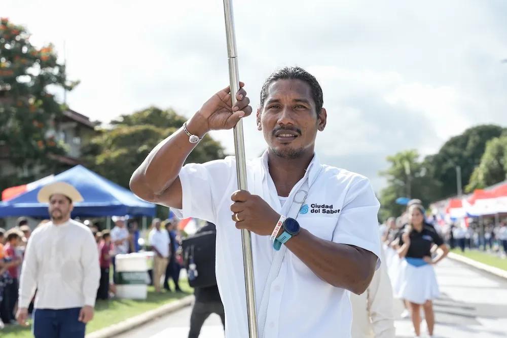 Hombre sostiene una bandera en algún desfile de Ciudad del Saber