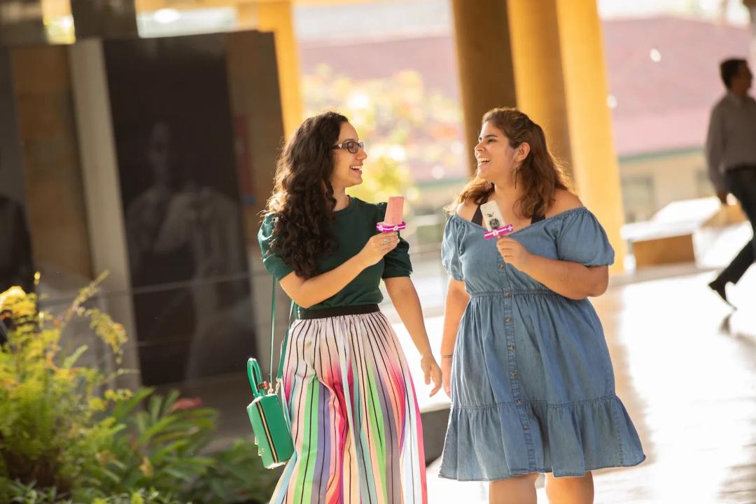 Dos mujer disfrutan de un helado mientras caminan el campus de Ciudad del Saber